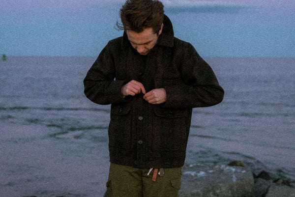 Man buttoning up the Iron Snail Mammoth jacket.